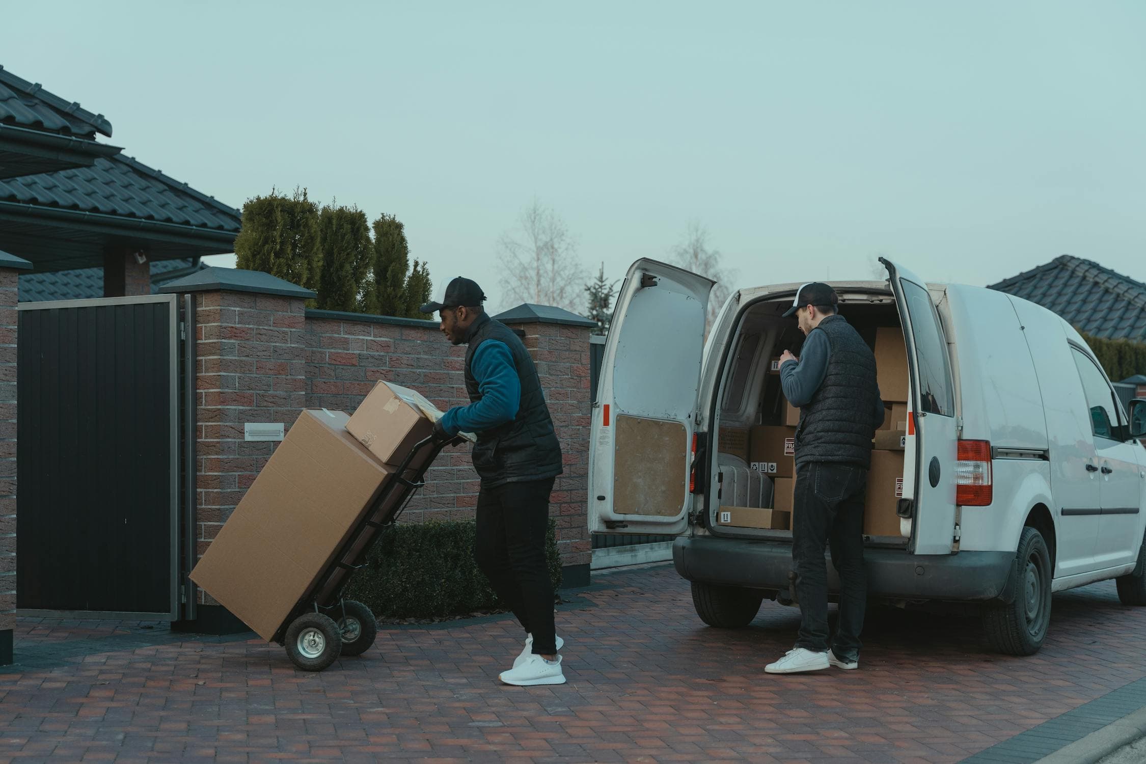 Two-man delivery team unloading packages from van